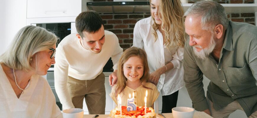 Привітання з днем народження внучці — A joyful family gathered around a birthday cake to celebrate a young girl's fifth birthday. | ITmaxService